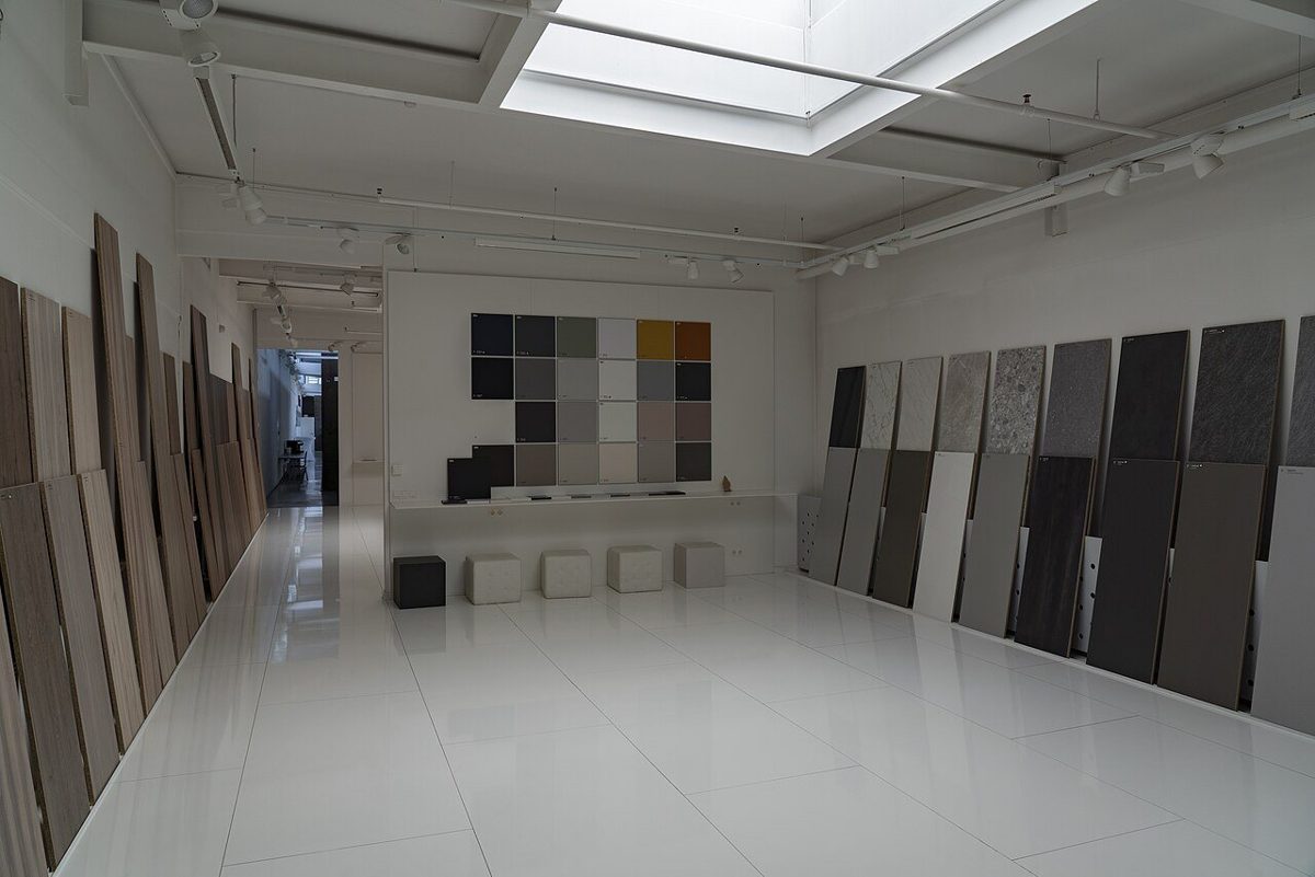 Showroom with tall wood-look and stone-look decor panel samples along both walls and a color sample grid