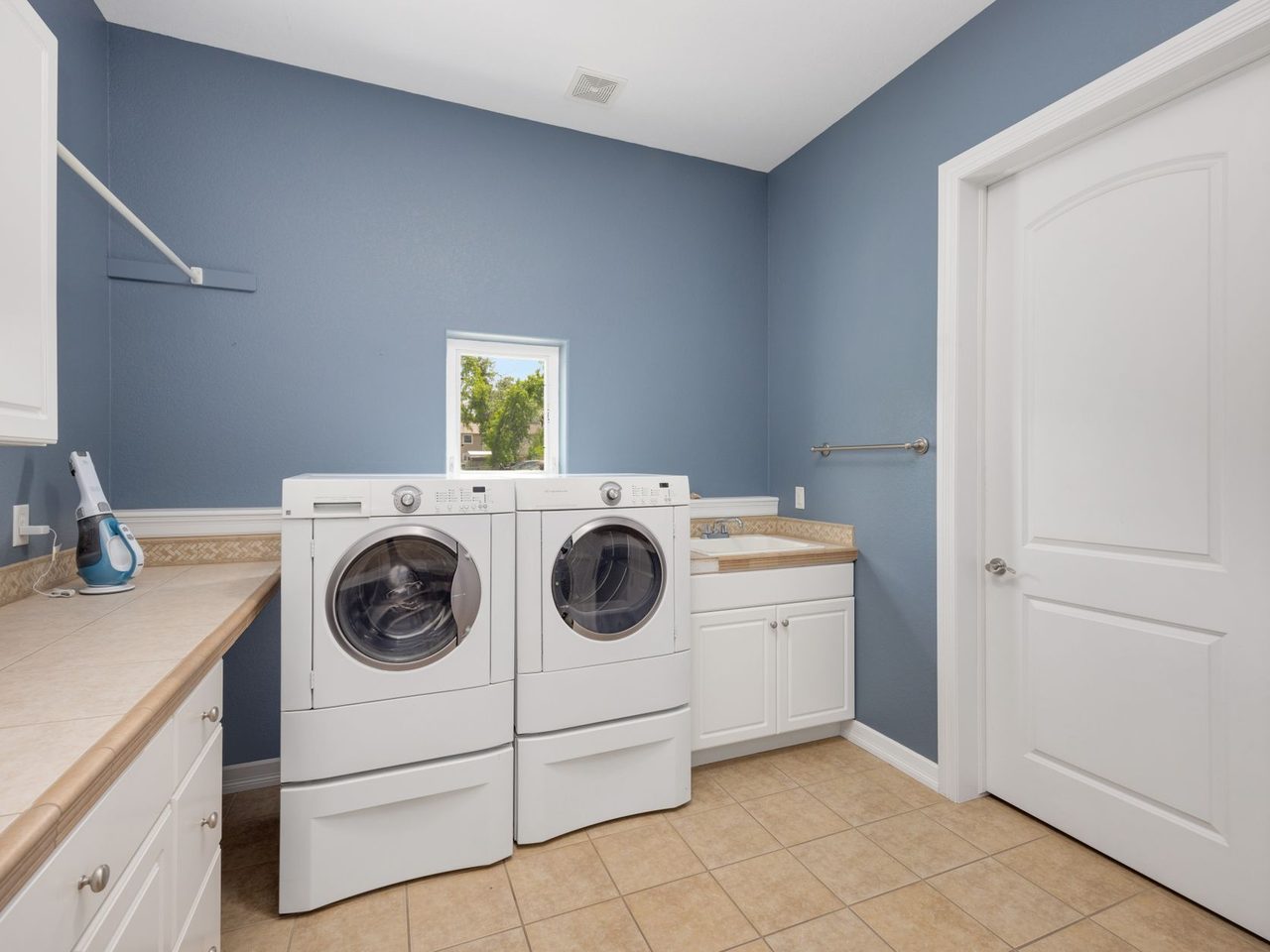 Laundry room with washer and dryer, blue walls and a tile floor