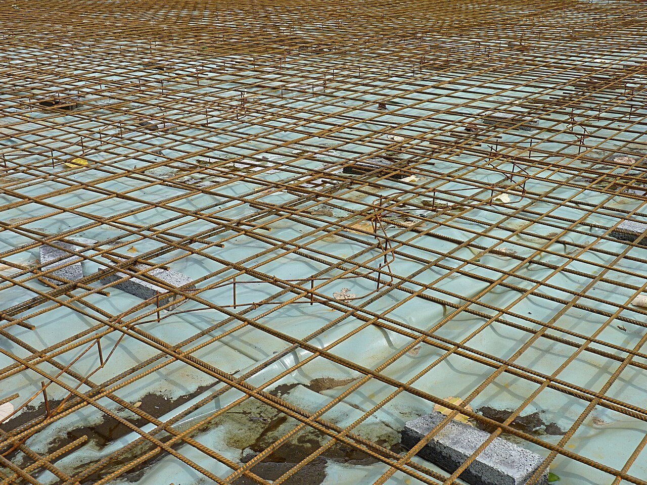 Rebar mesh supported on spacers above a plastic sheet membrane before a concrete pour