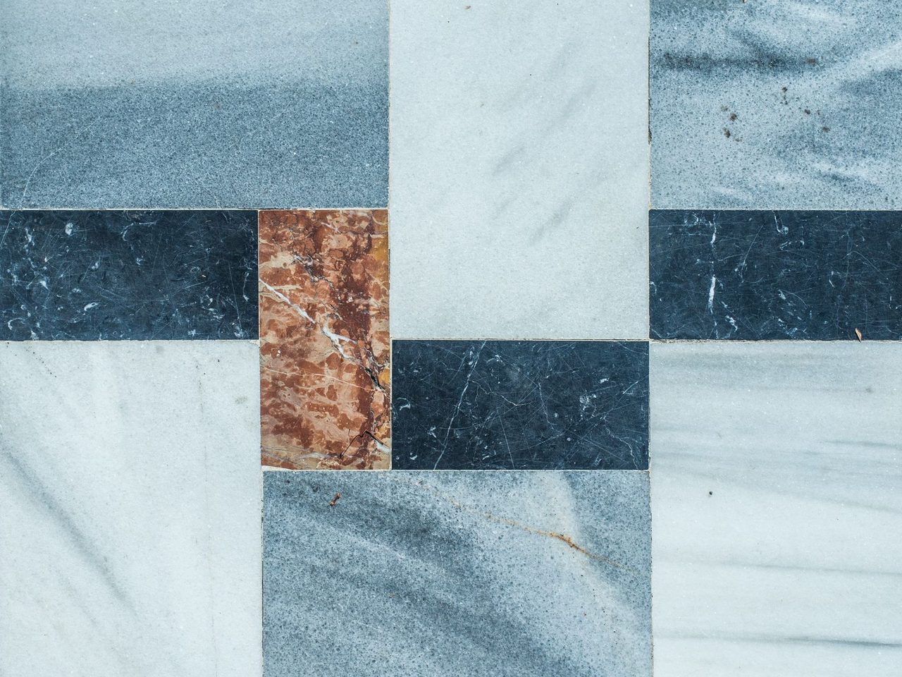 Close-up of stone tiles in a geometric pattern of blue, white and red