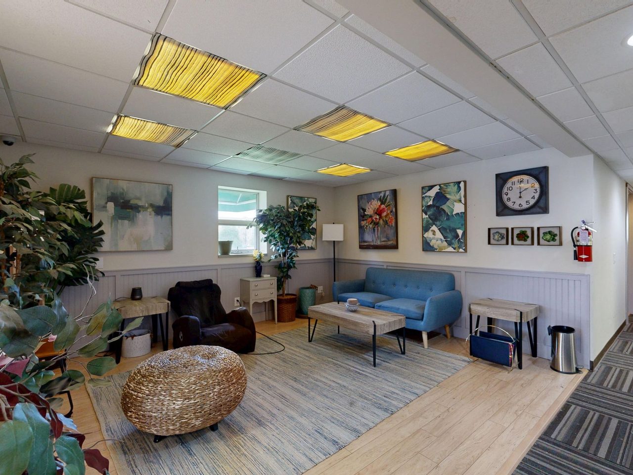 Office lounge with sofas, a coffee table and carpet tile at the edge