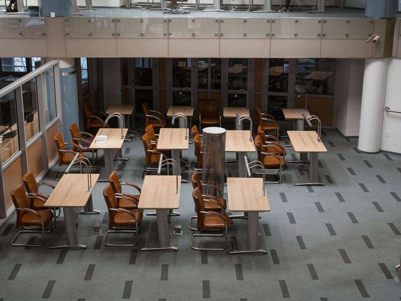 Overhead view of rows of tables and chairs on patterned carpet