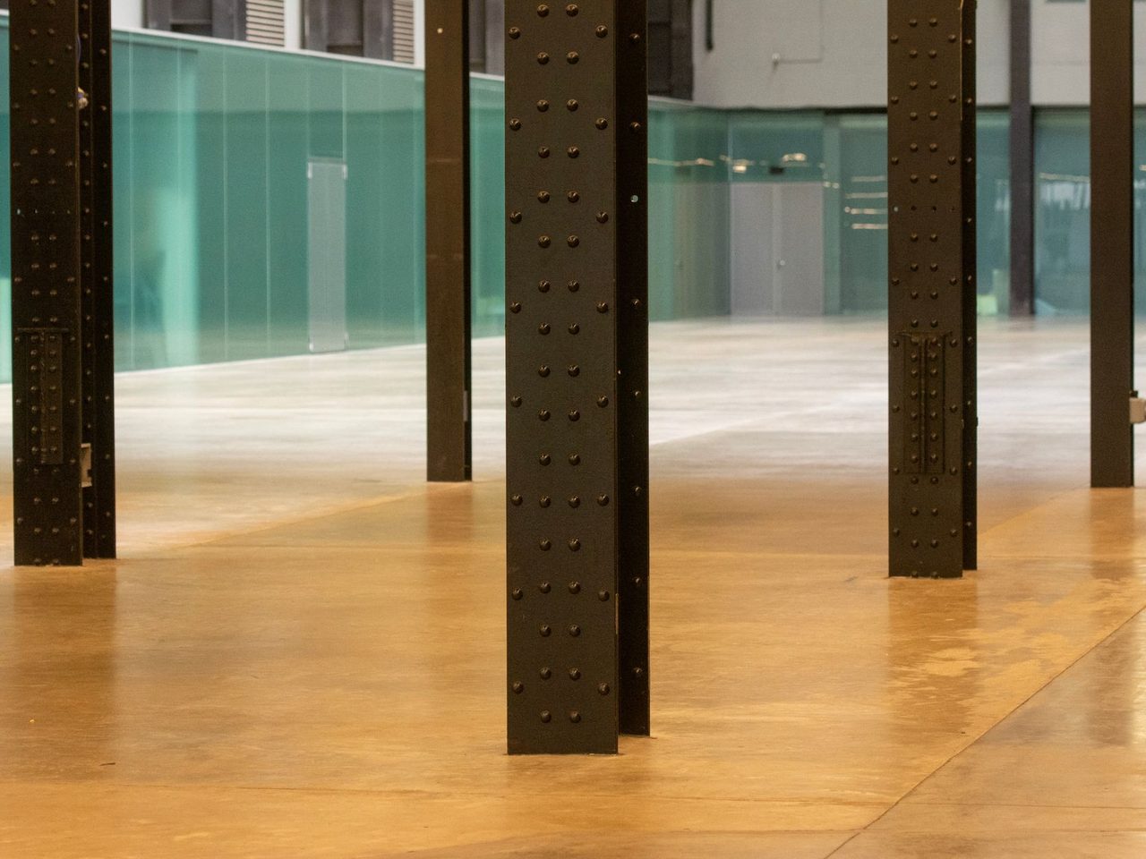 Large interior with dark steel columns standing on a polished floor