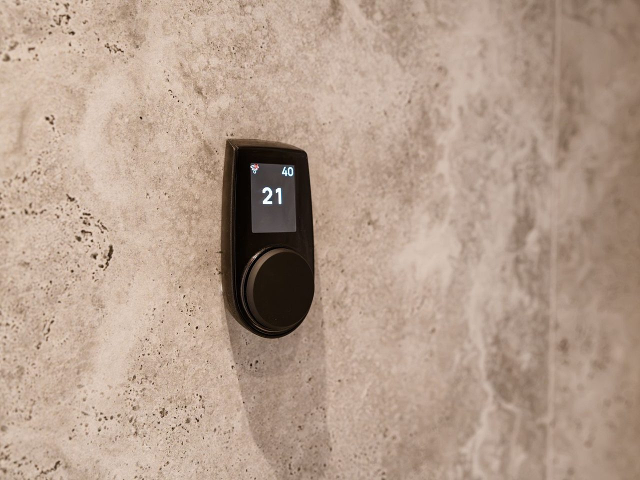 Digital temperature control mounted on a textured stone wall