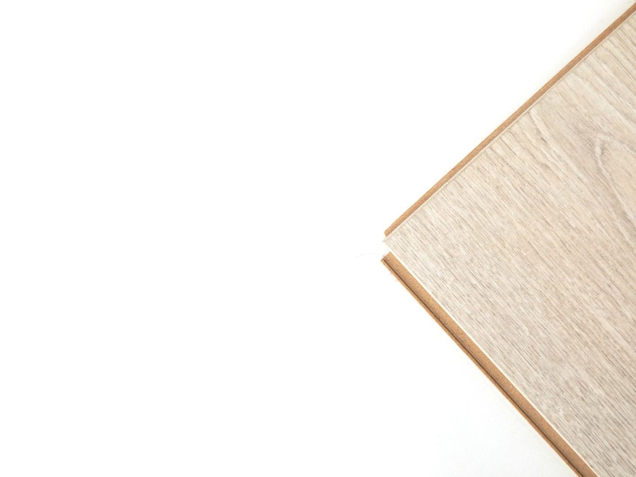 Edge of a light wood-look plank showing its locking profile against a white background