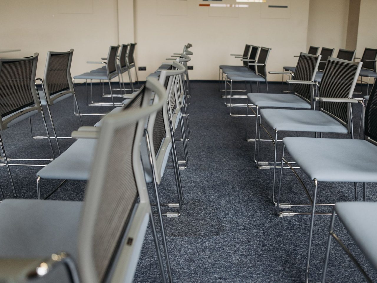 Meeting room with rows of chairs on dark carpet