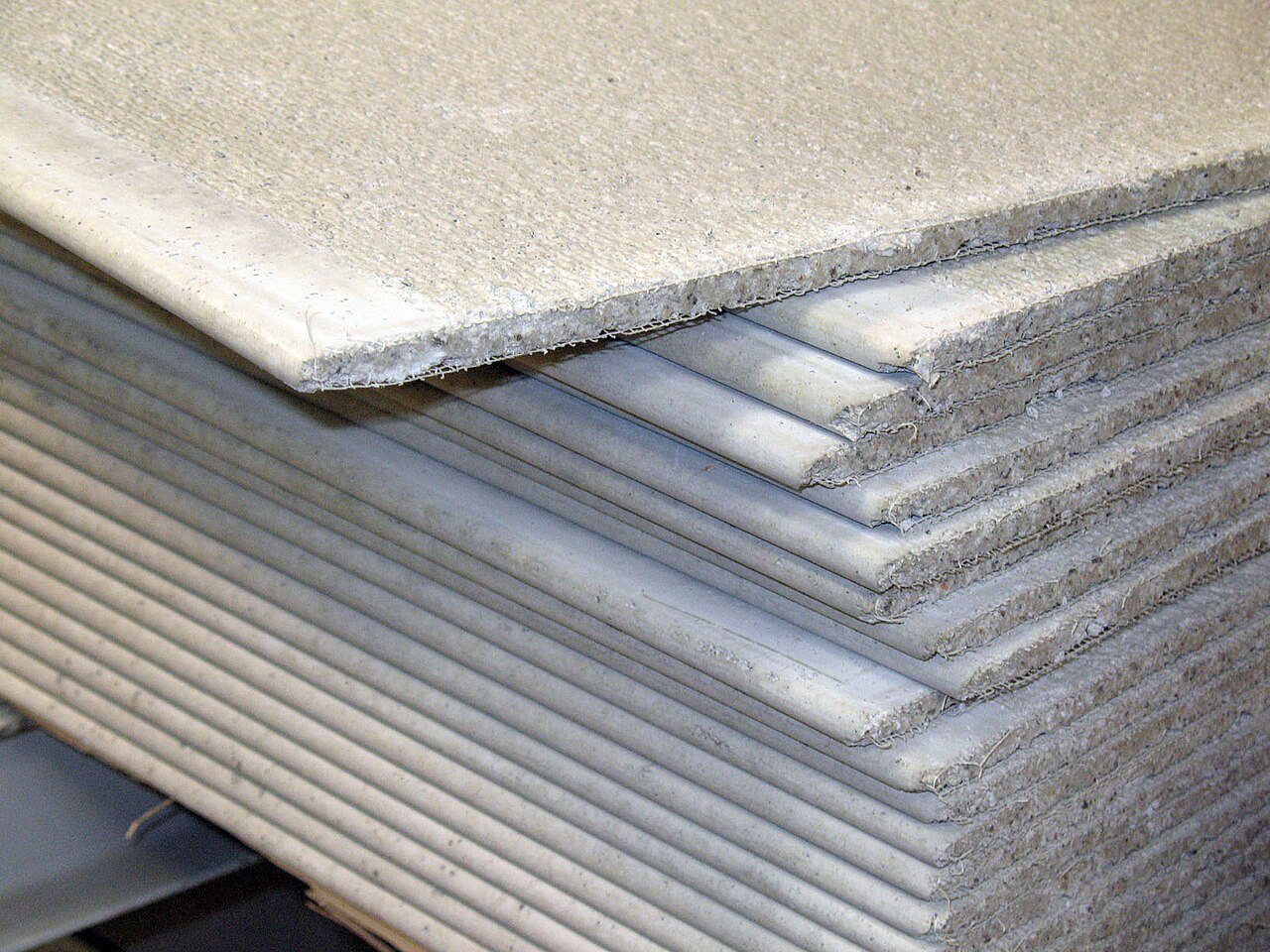 Stack of cement backer boards with rough fibrous edges