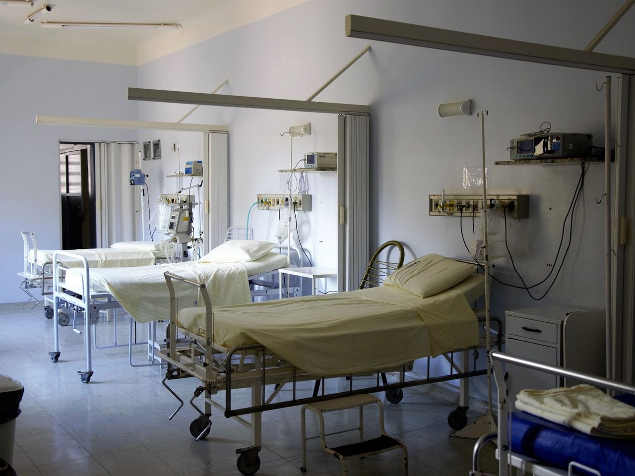 Hospital ward with several empty beds and medical equipment
