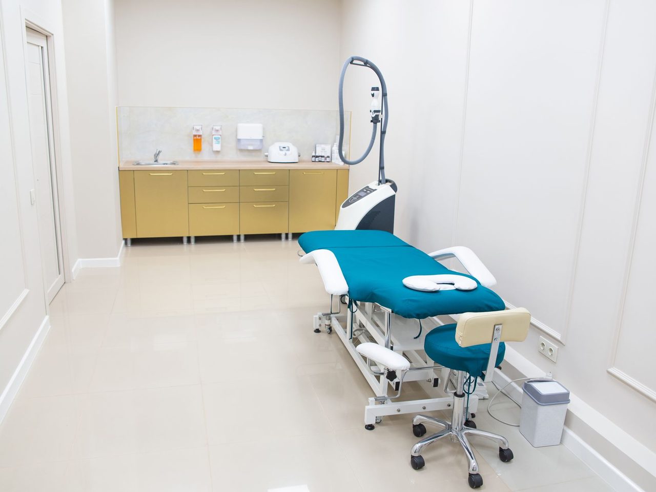 Medical examination room with a treatment chair, a pale floor and white walls