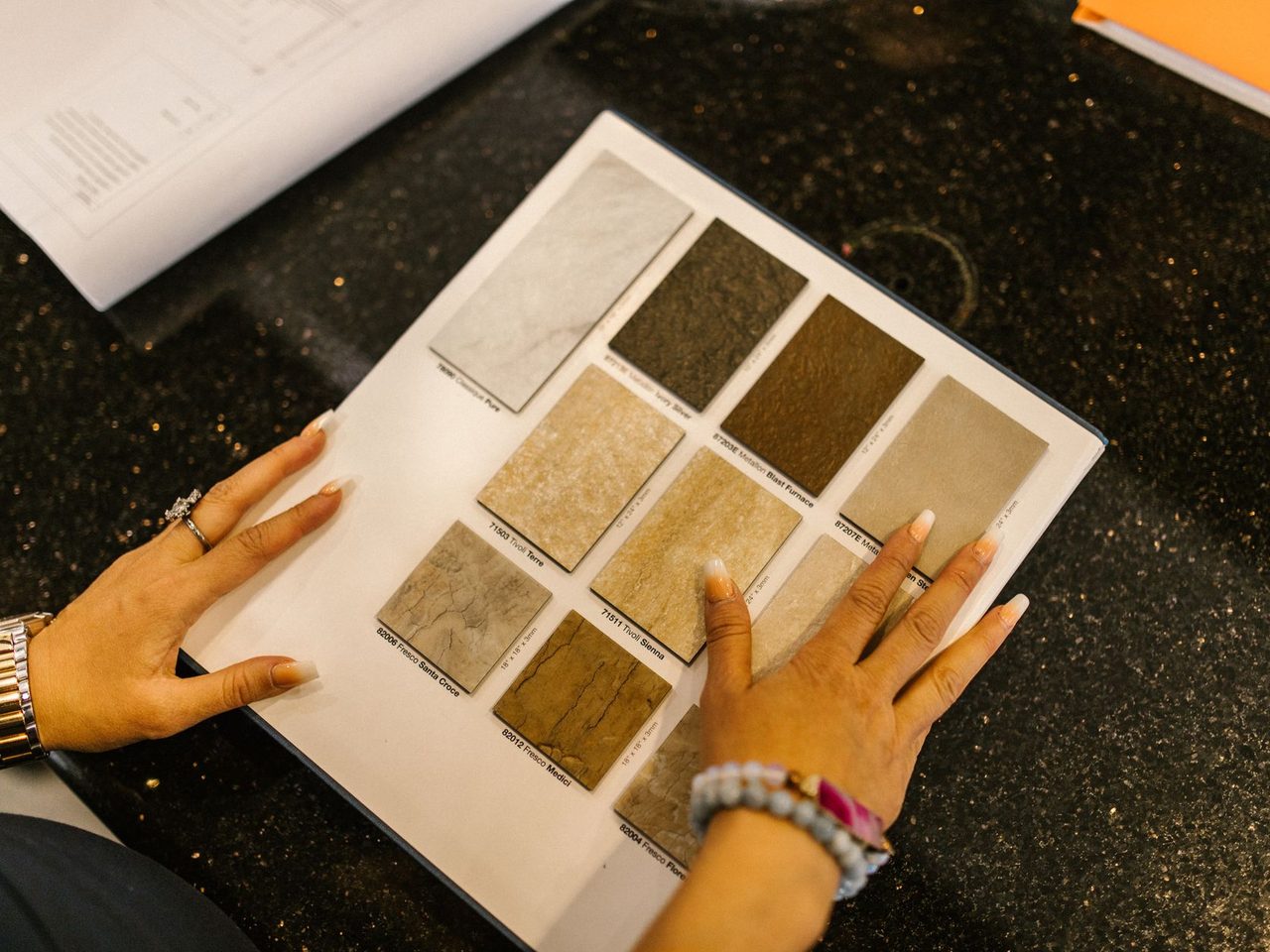 Hand resting on a sample board of stone finishes