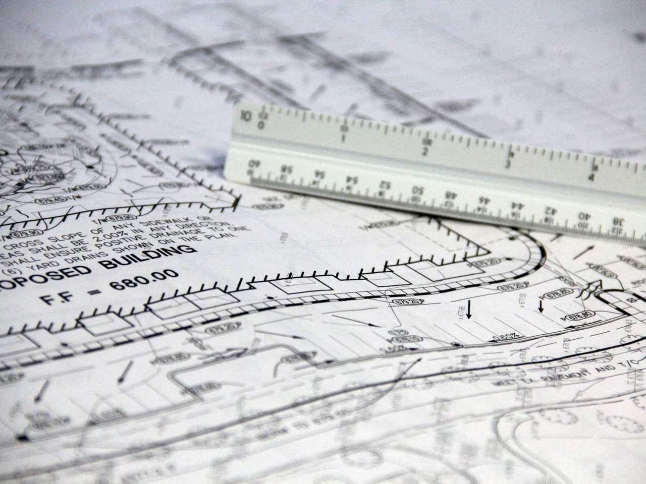Close-up of architectural blueprints with a scale ruler