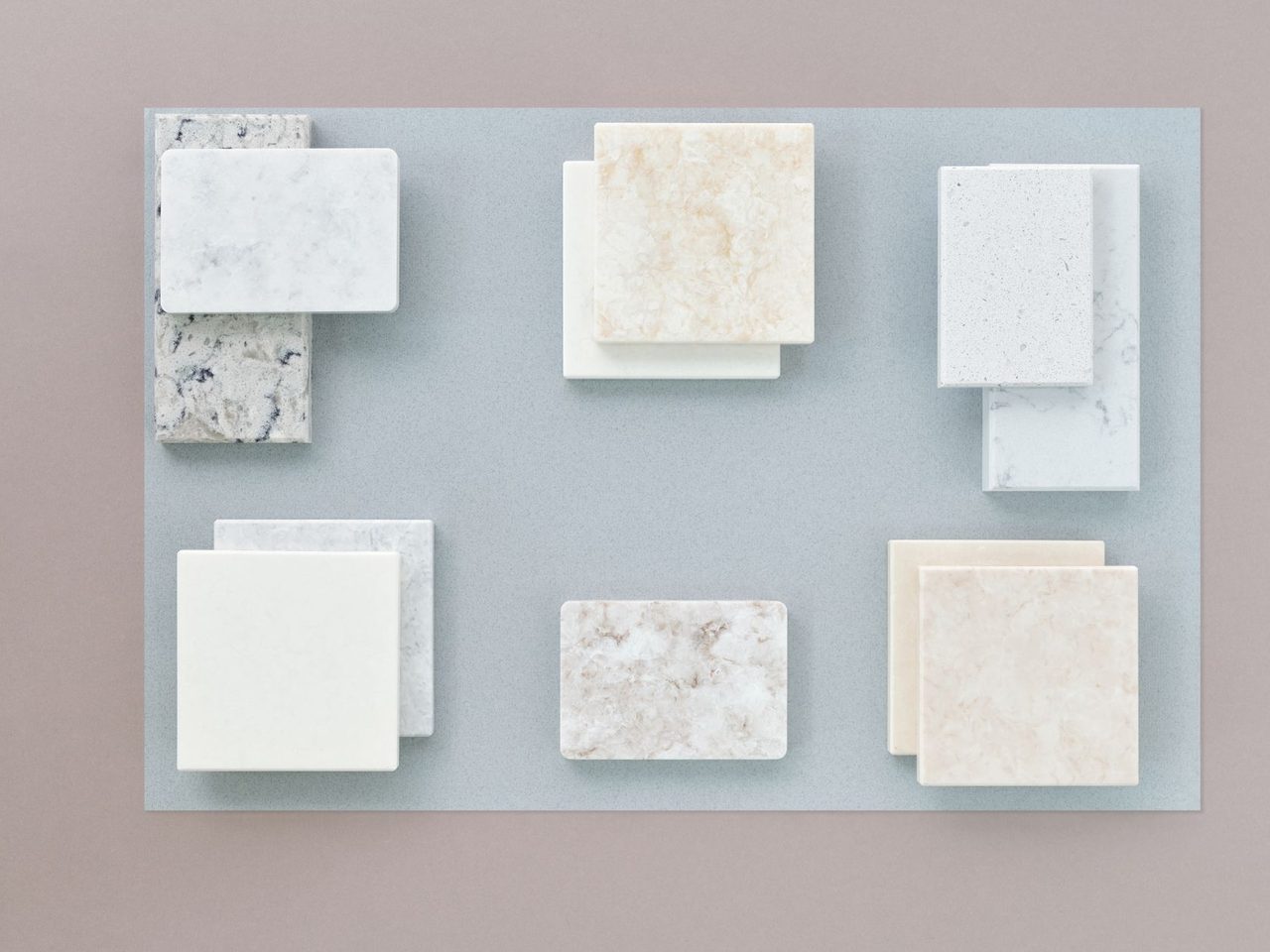 Flat lay of several stone tile samples on a pale board