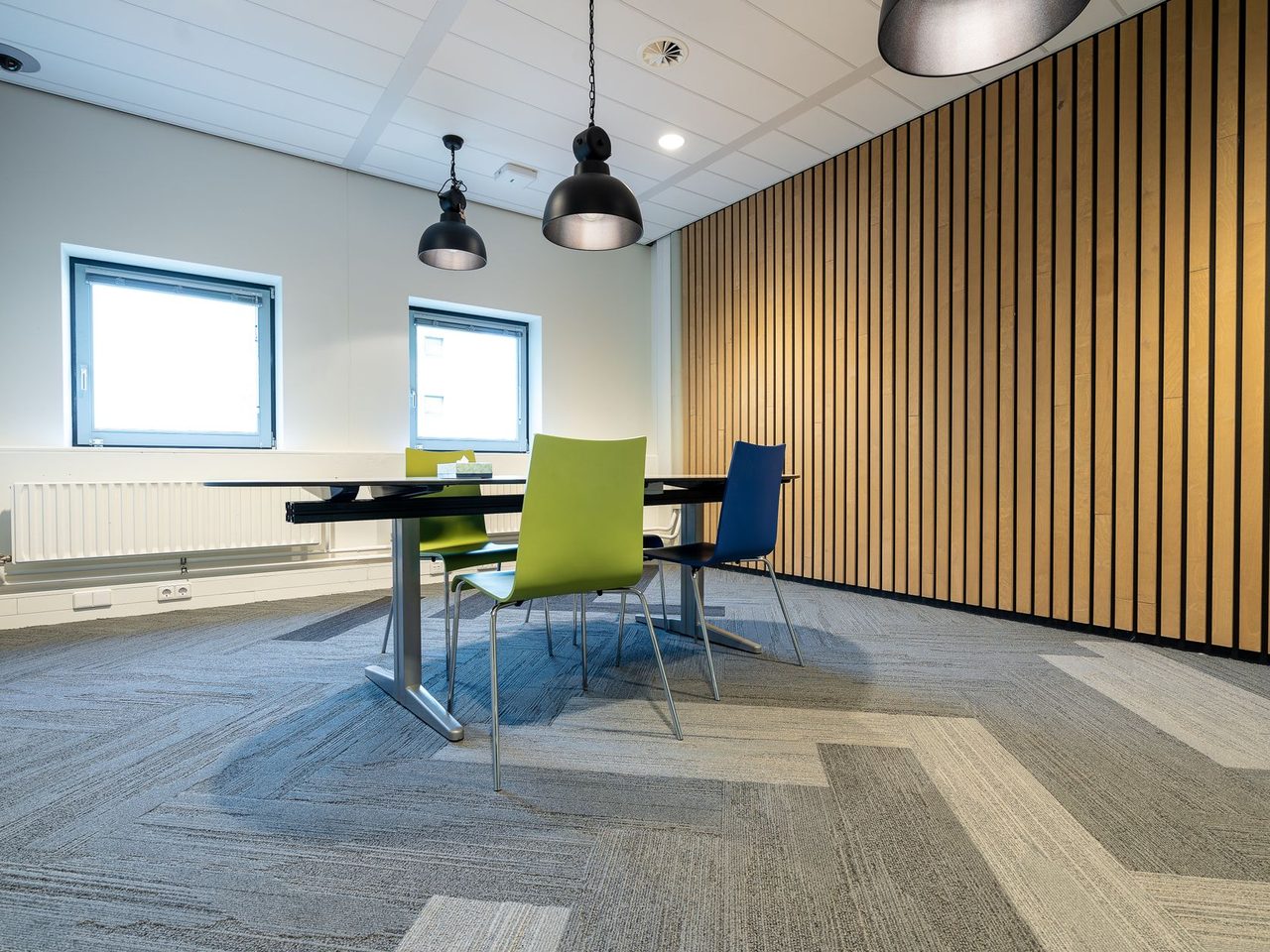 Meeting room with carpet tile flooring and a slatted wood wall