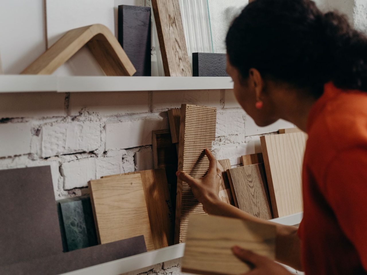 Person choosing wood flooring samples in a showroom