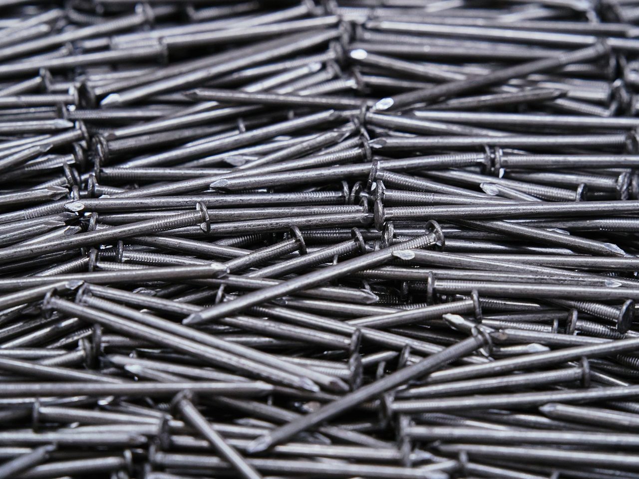 Close-up of a dense pile of steel nails