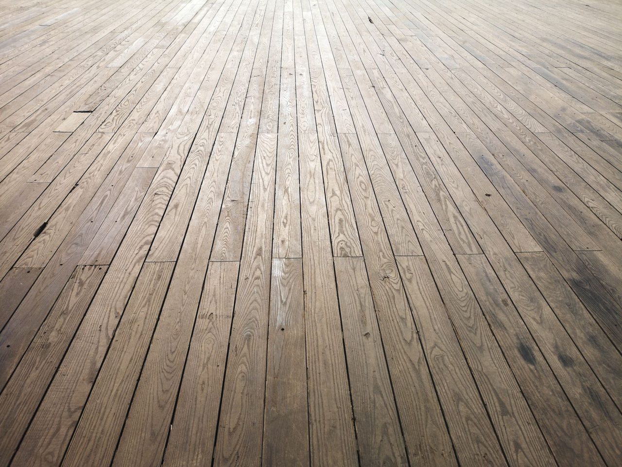 Wide view across an aged wood plank floor