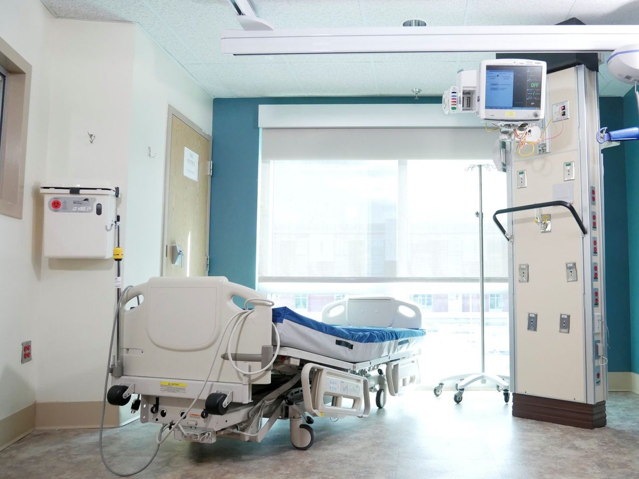 Hospital room with a bed and medical equipment on a sheet floor