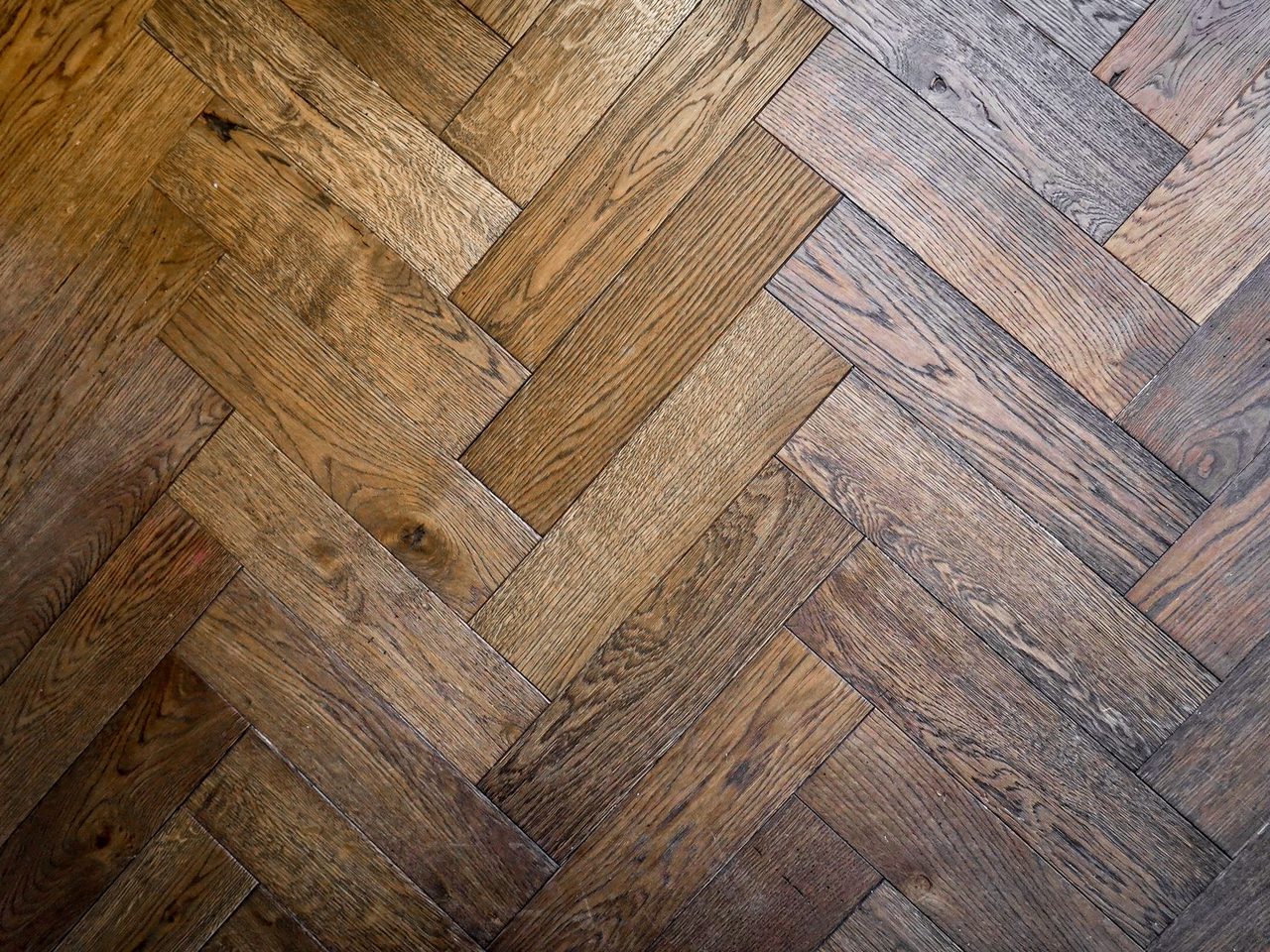 Close-up of a herringbone wood-look floor in warm brown tones