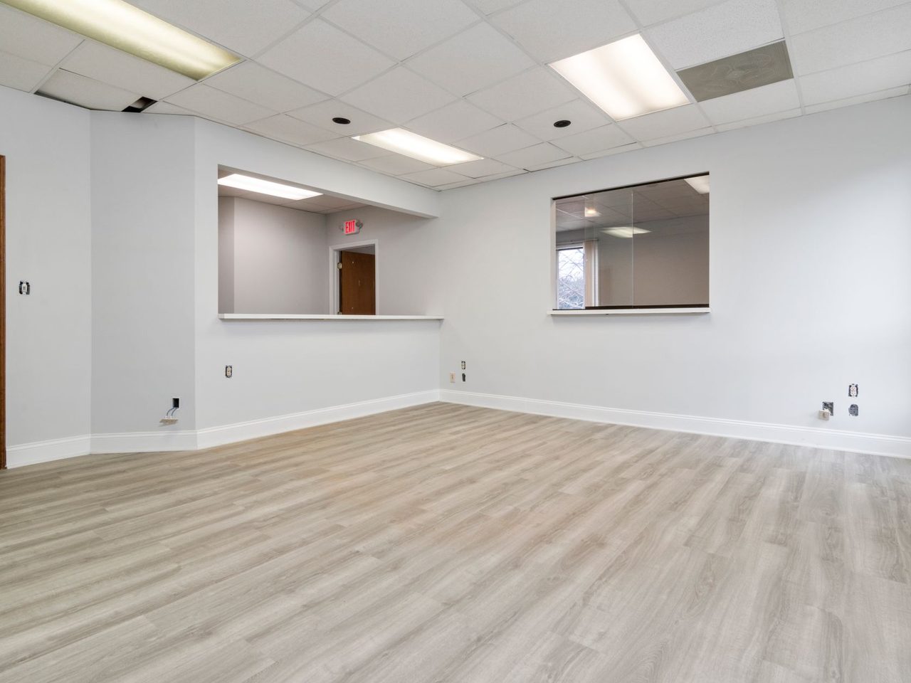Empty office space with a wood-look floor and recessed lighting