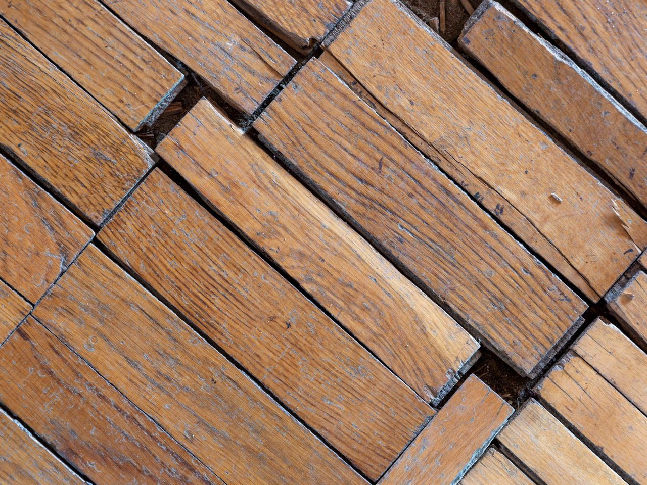 Close-up of aged floorboards that have lifted and separated at their joints
