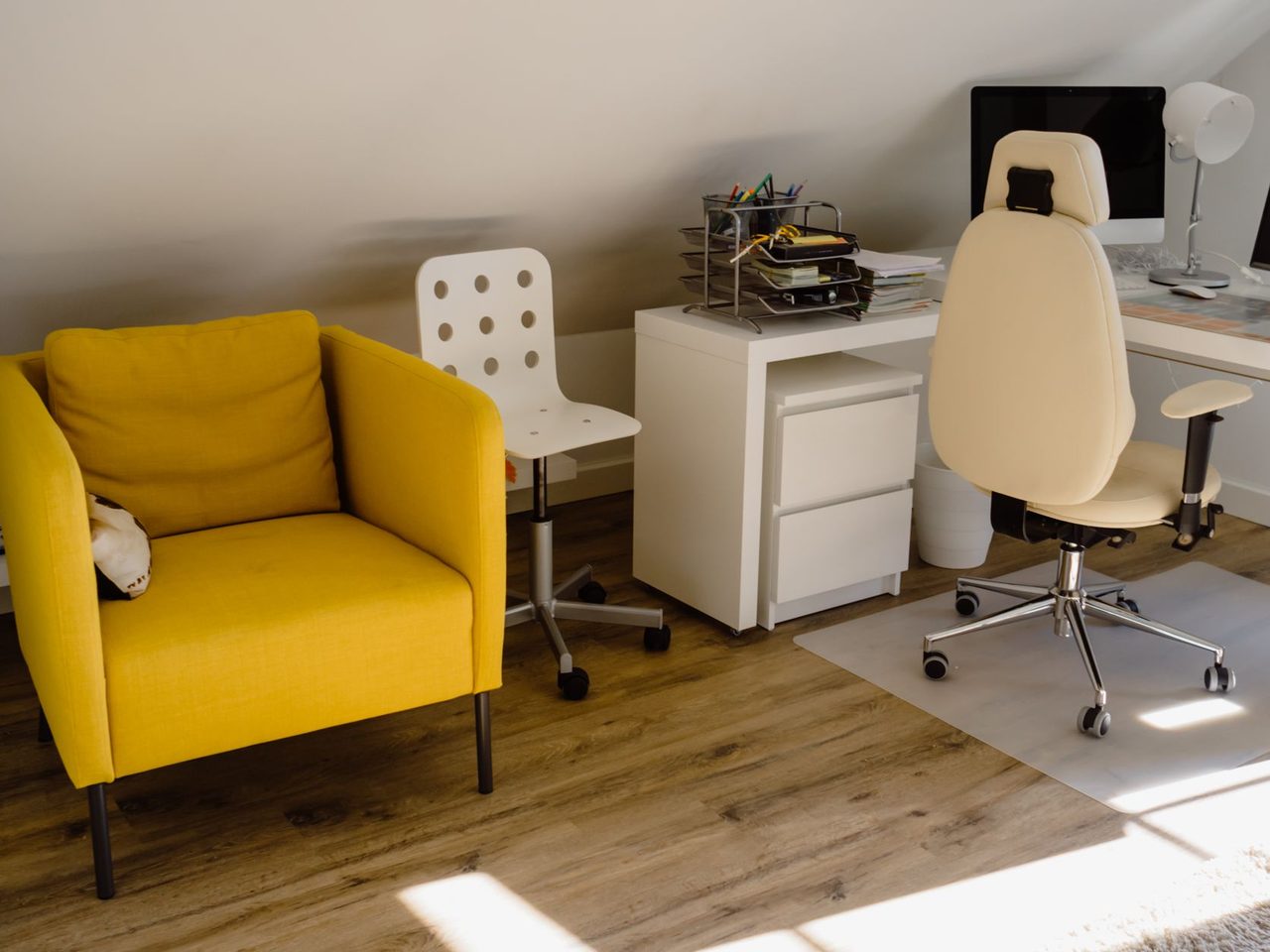 Home office with a clear chair mat under a desk chair on a wood-look plank floor