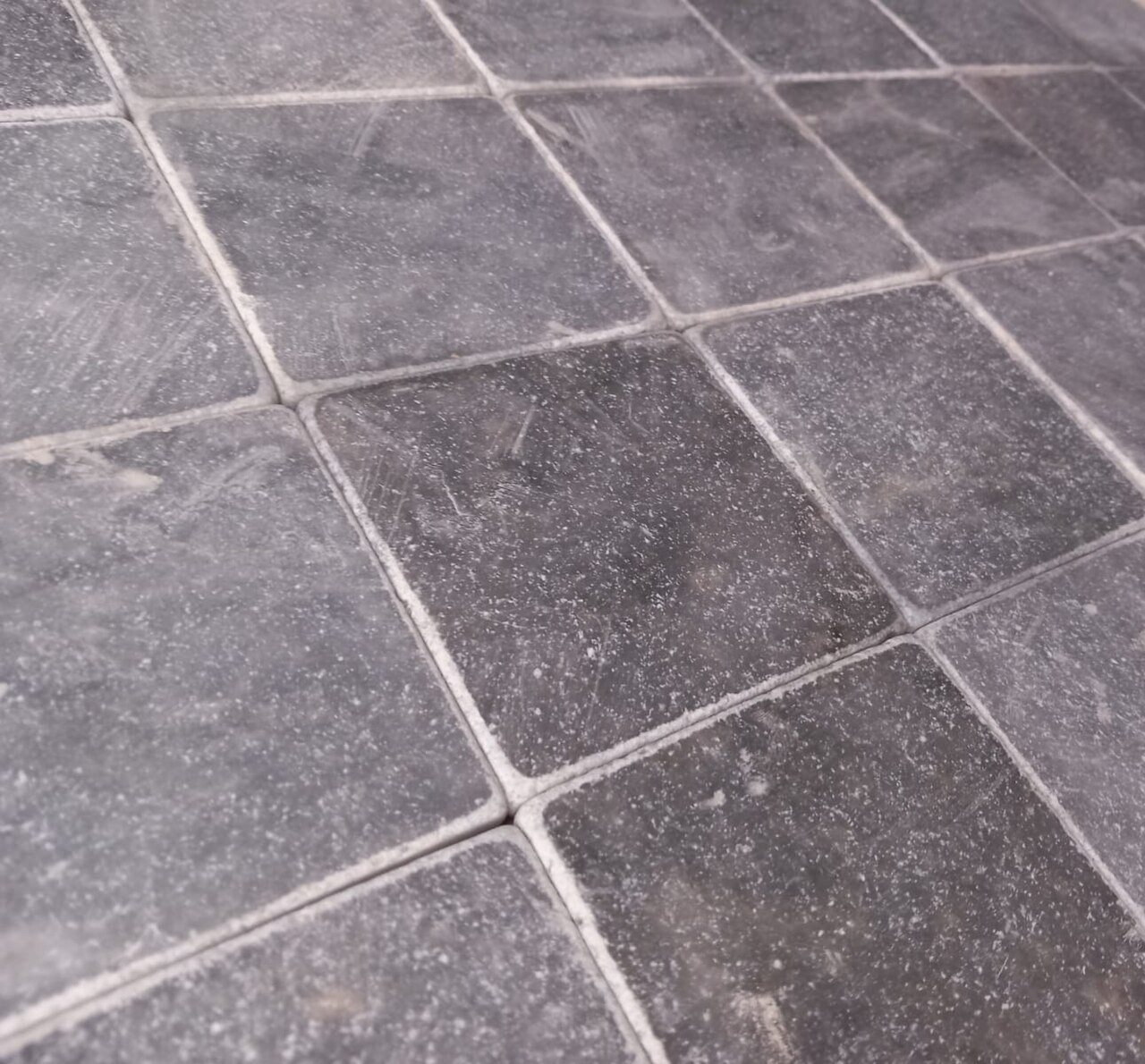 Close-up of dark grey natural stone floor tiles with light grout joints