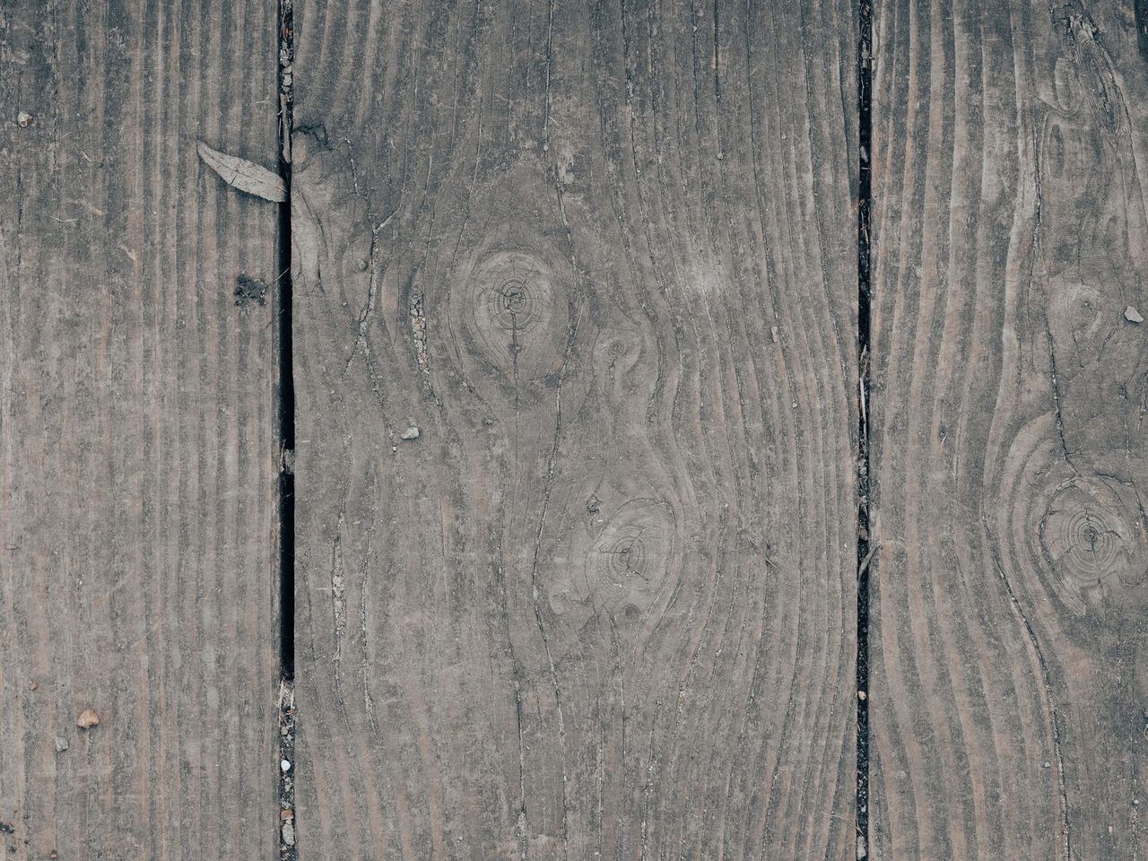Weathered gray boards with open dark gaps between them
