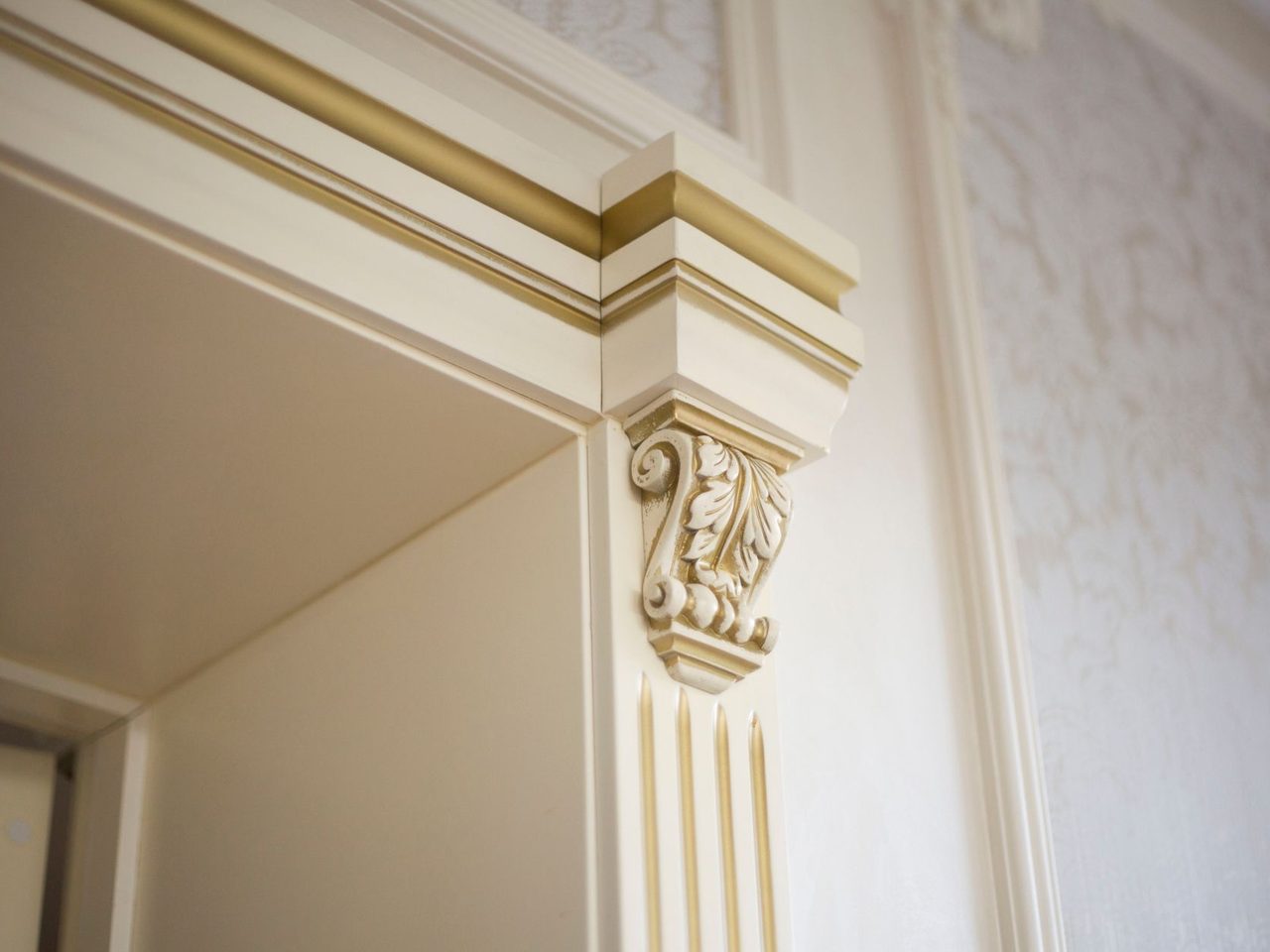Close-up of ornamental crown and pilaster molding at a room corner