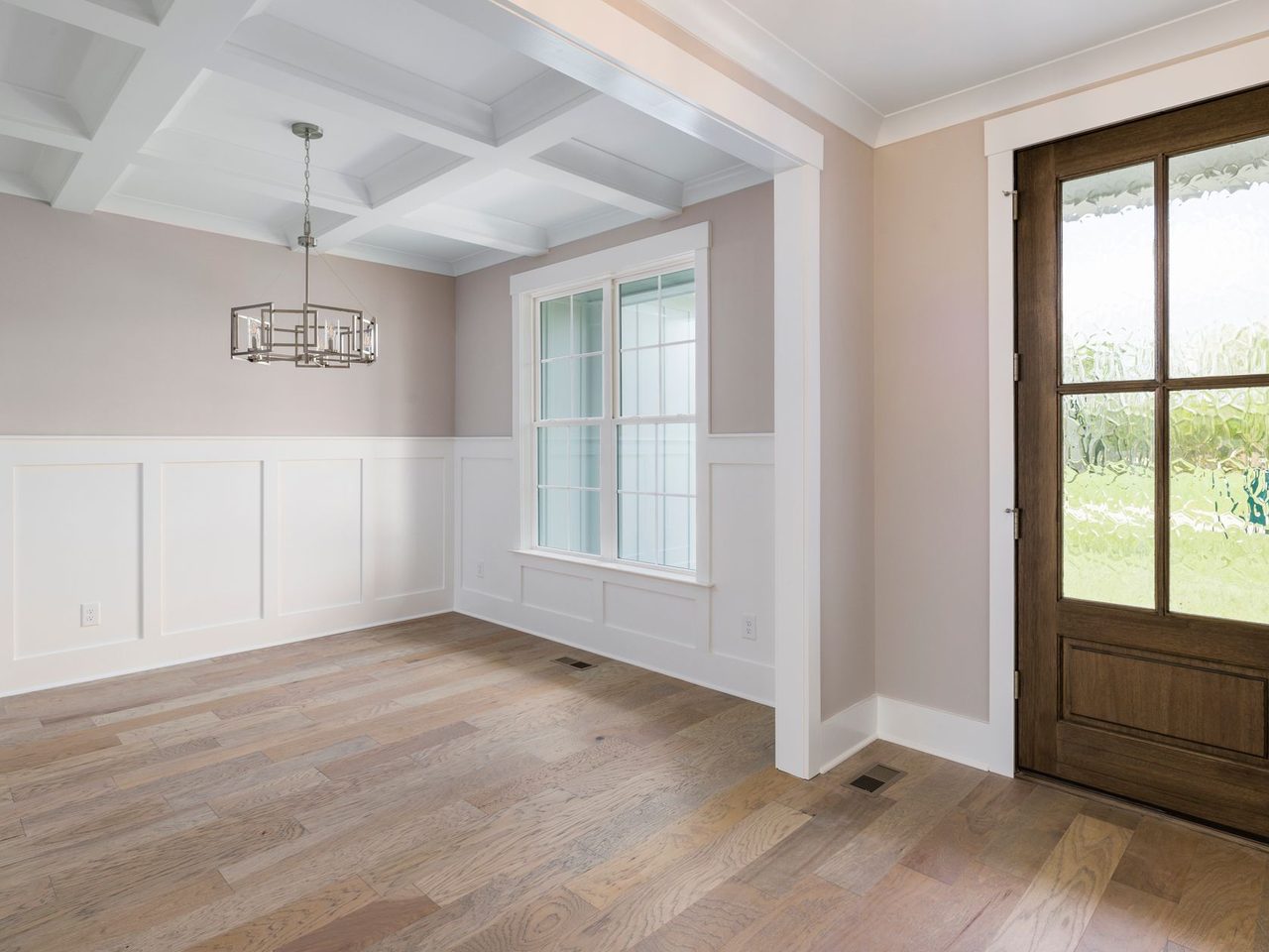 Entry with white wainscoting, a wood front door and a wood-look floor