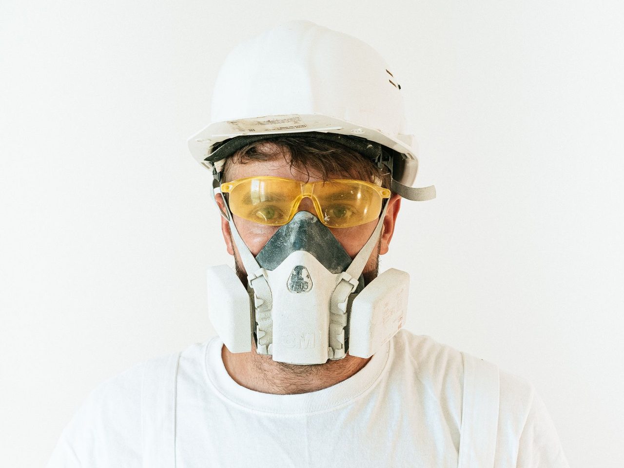 Construction worker wearing a hard hat, safety goggles and a respirator mask