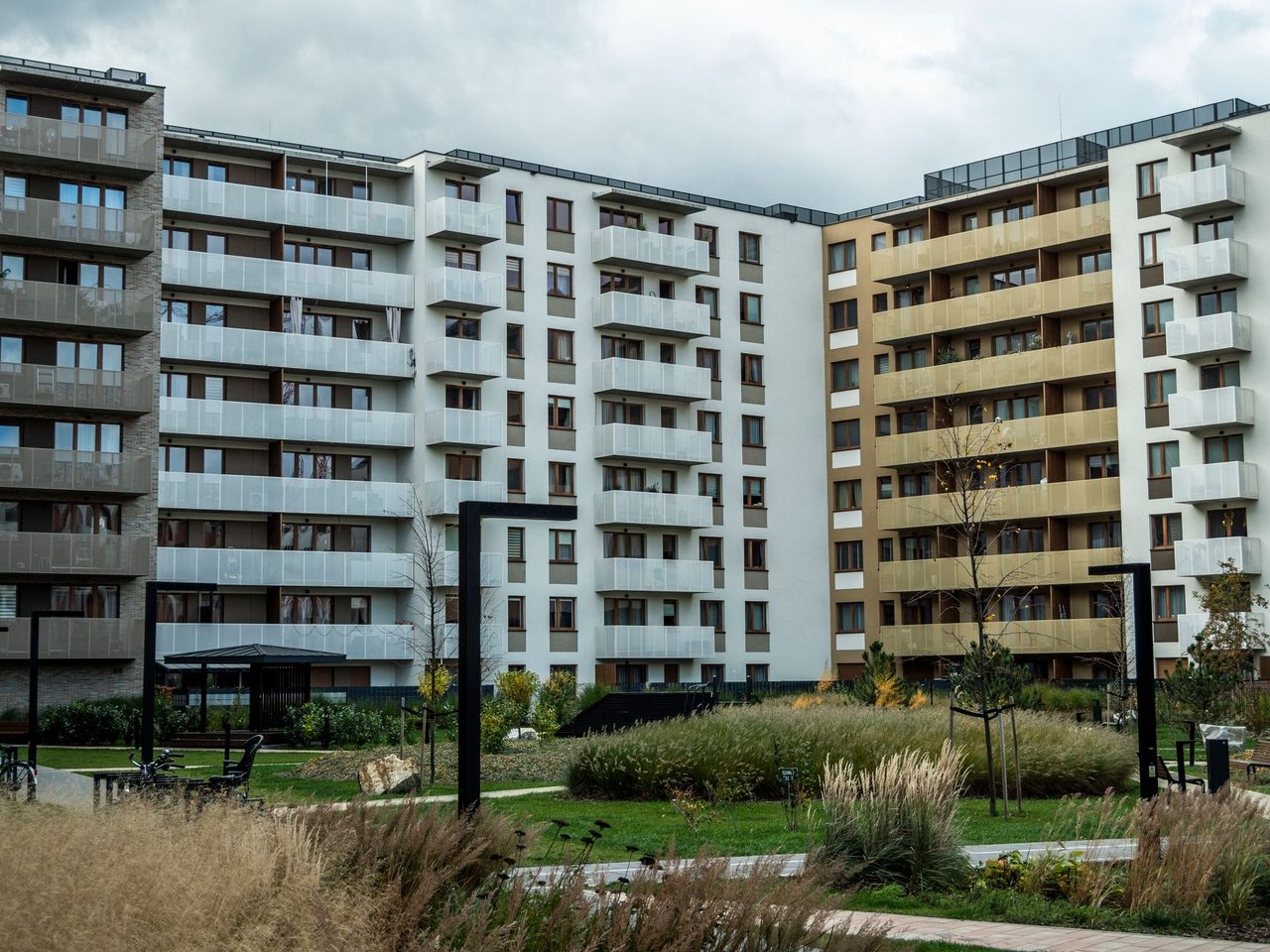 Modern apartment building with balconies behind landscaped grounds