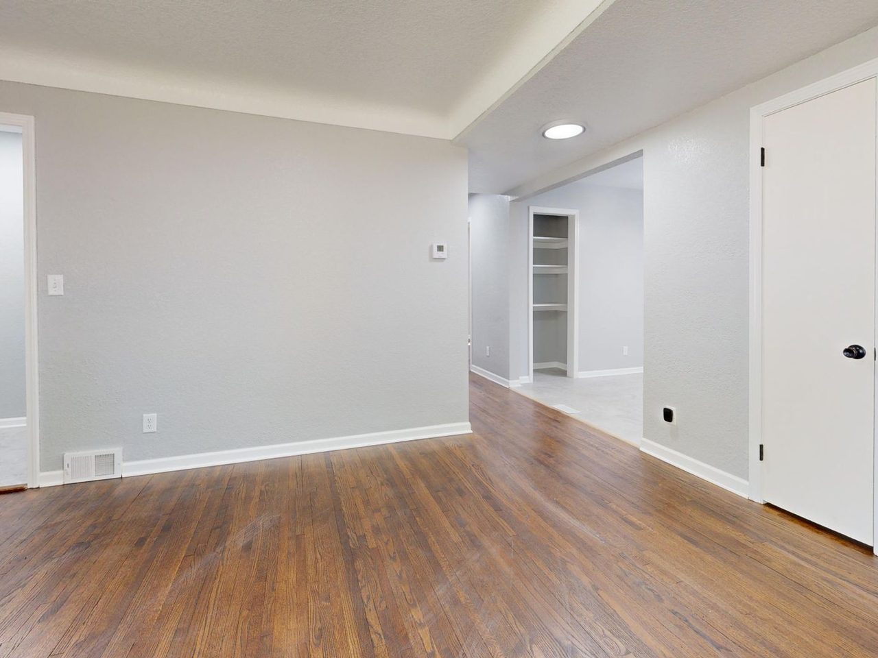 Empty room with gray walls and a wood-look plank floor