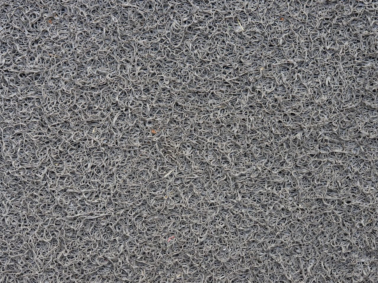 Close-up of a gray synthetic mat with looped fibers