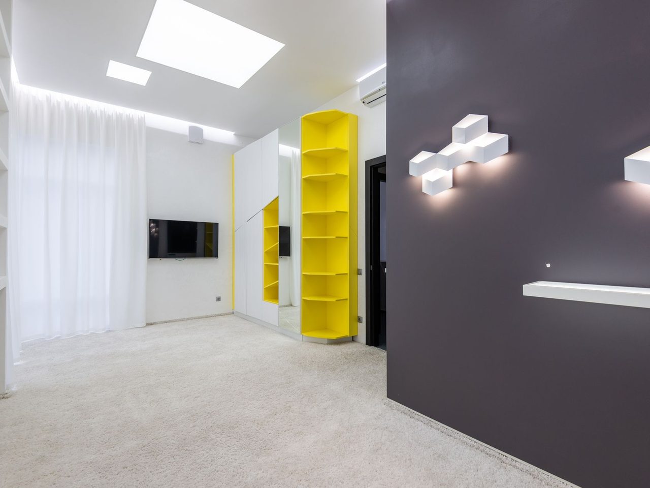 Empty modern room with light carpet and a dark accent wall