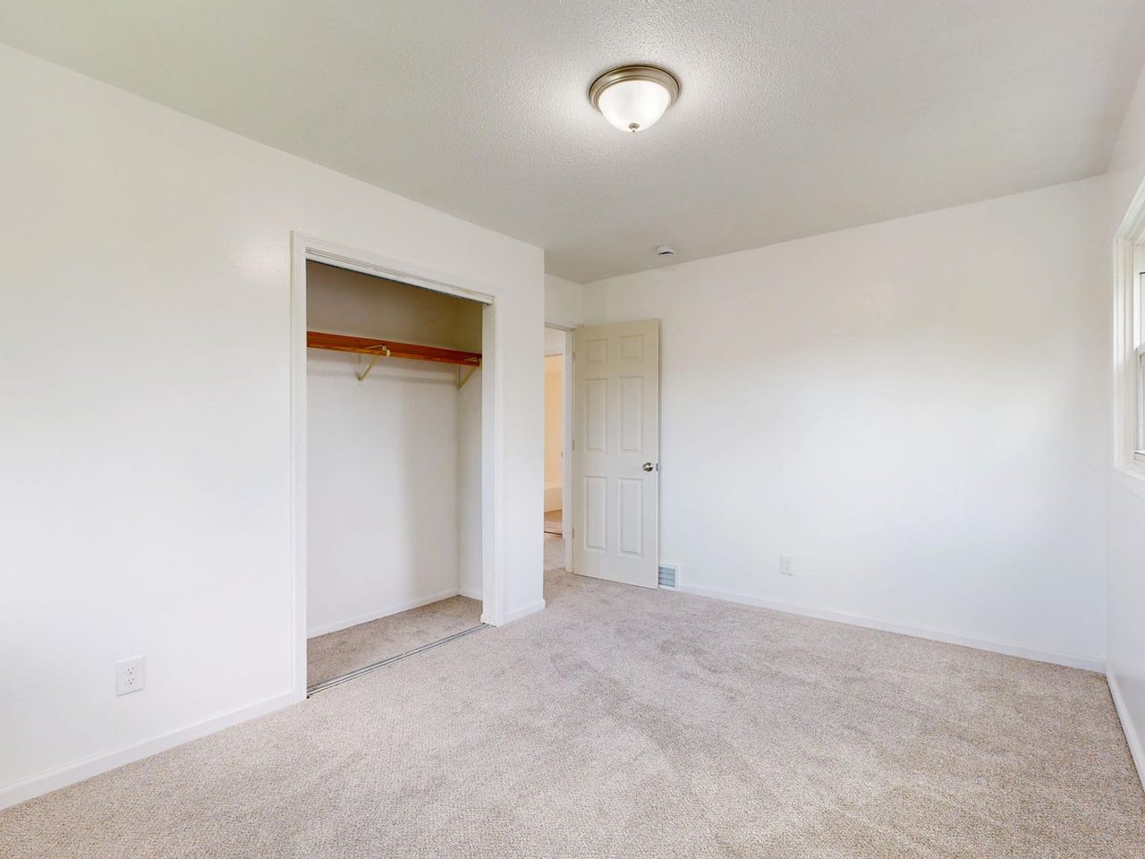 Empty room with plush carpet and an open closet