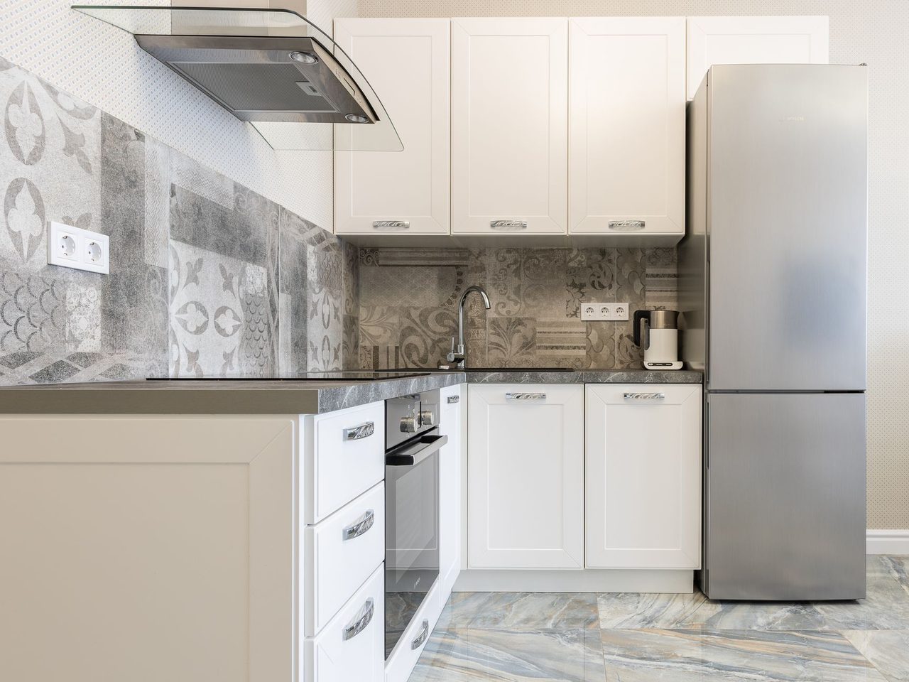 Modern kitchen with white cabinets and a patterned stone-look floor