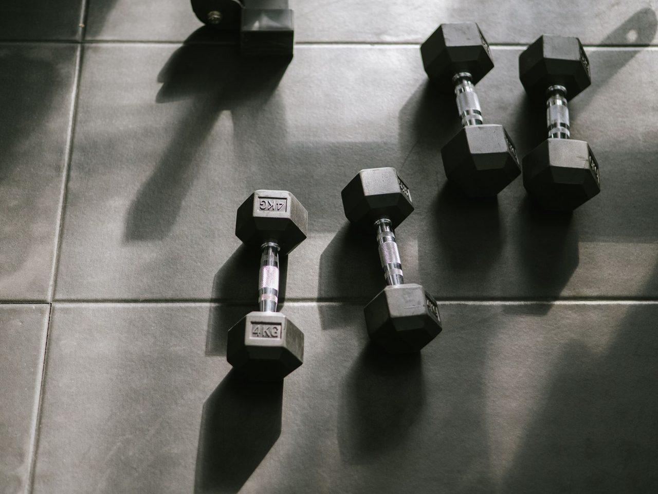 Hexagonal dumbbells on a rubber floor with strong shadows