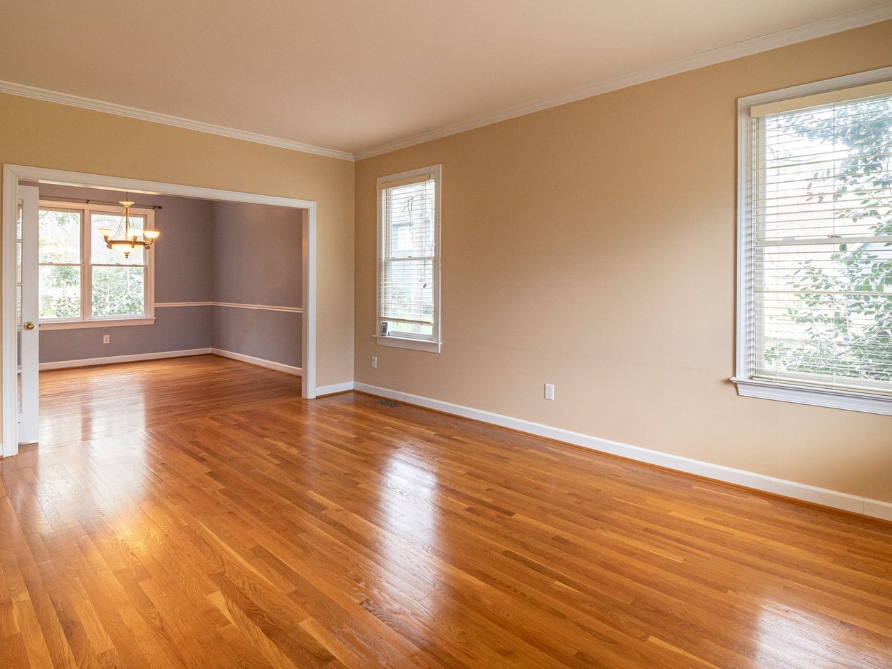 Empty room with a glossy hardwood floor and large windows