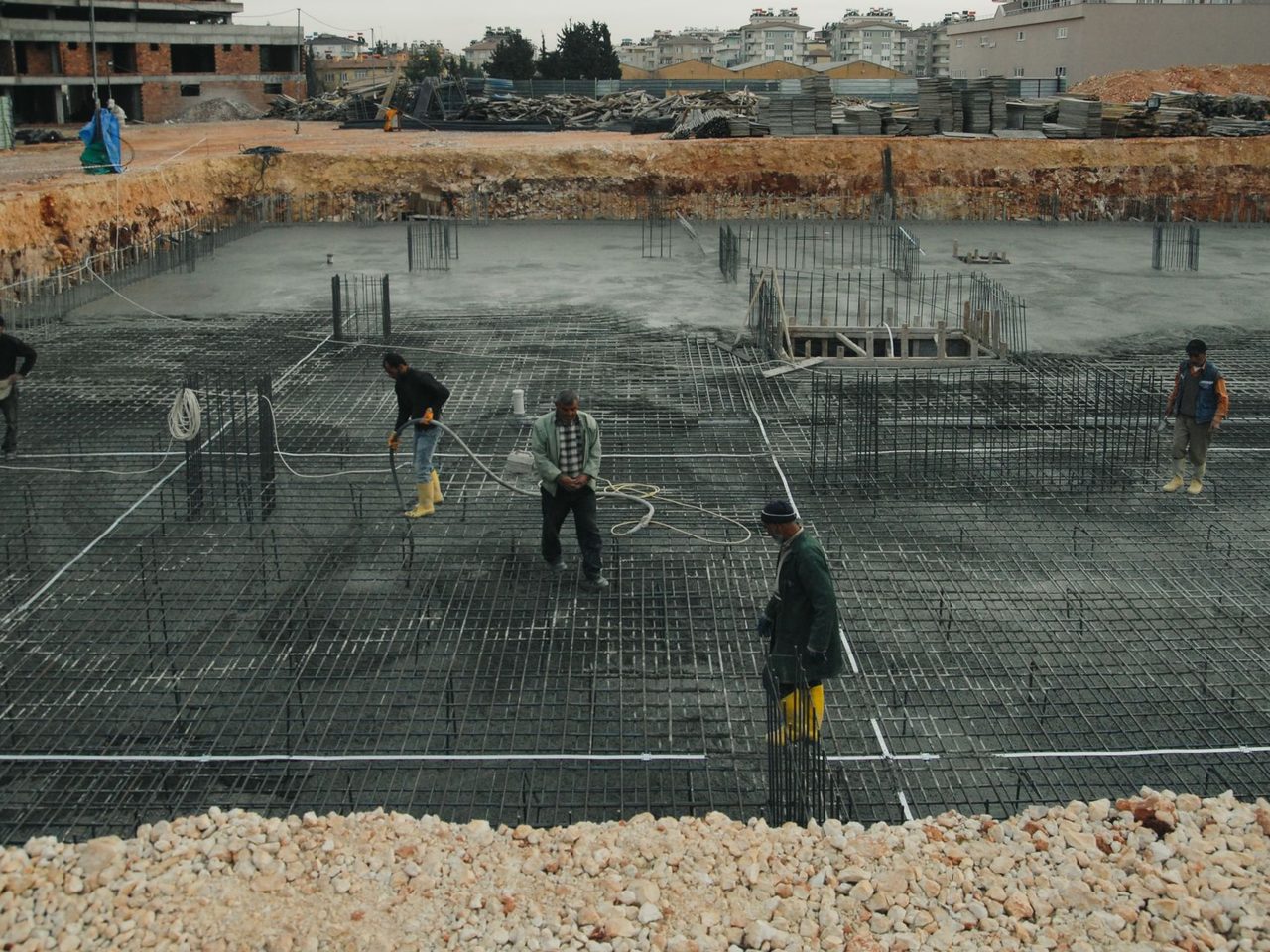 Construction site with workers placing reinforcing steel before a slab pour