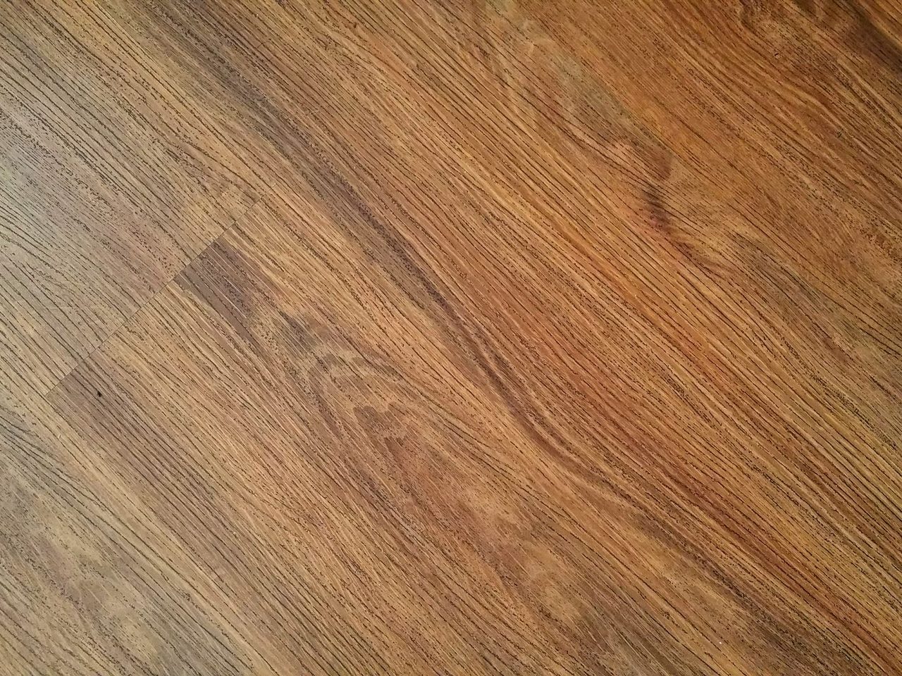 Close-up of a brown wood-look plank floor with visible grain