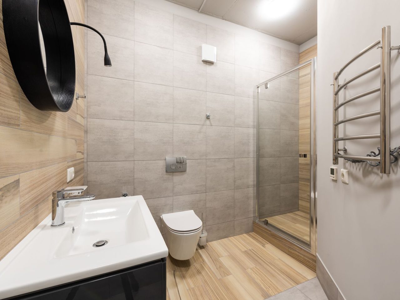 Bathroom with large-format gray wall tile and a wood-look tile floor