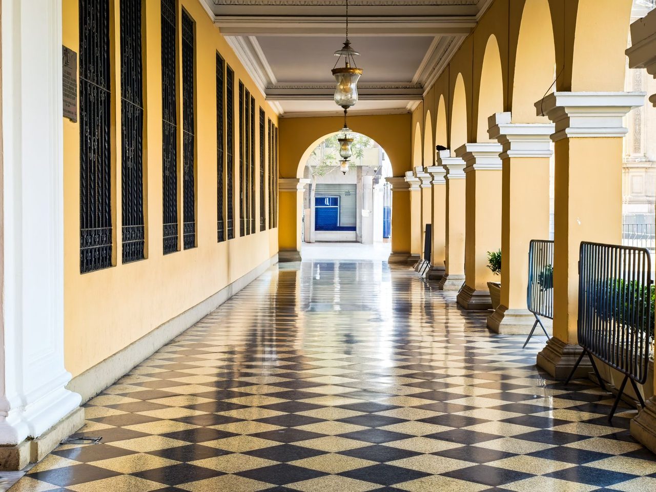 Colonial-style arcade with a black and white checkered tile floor