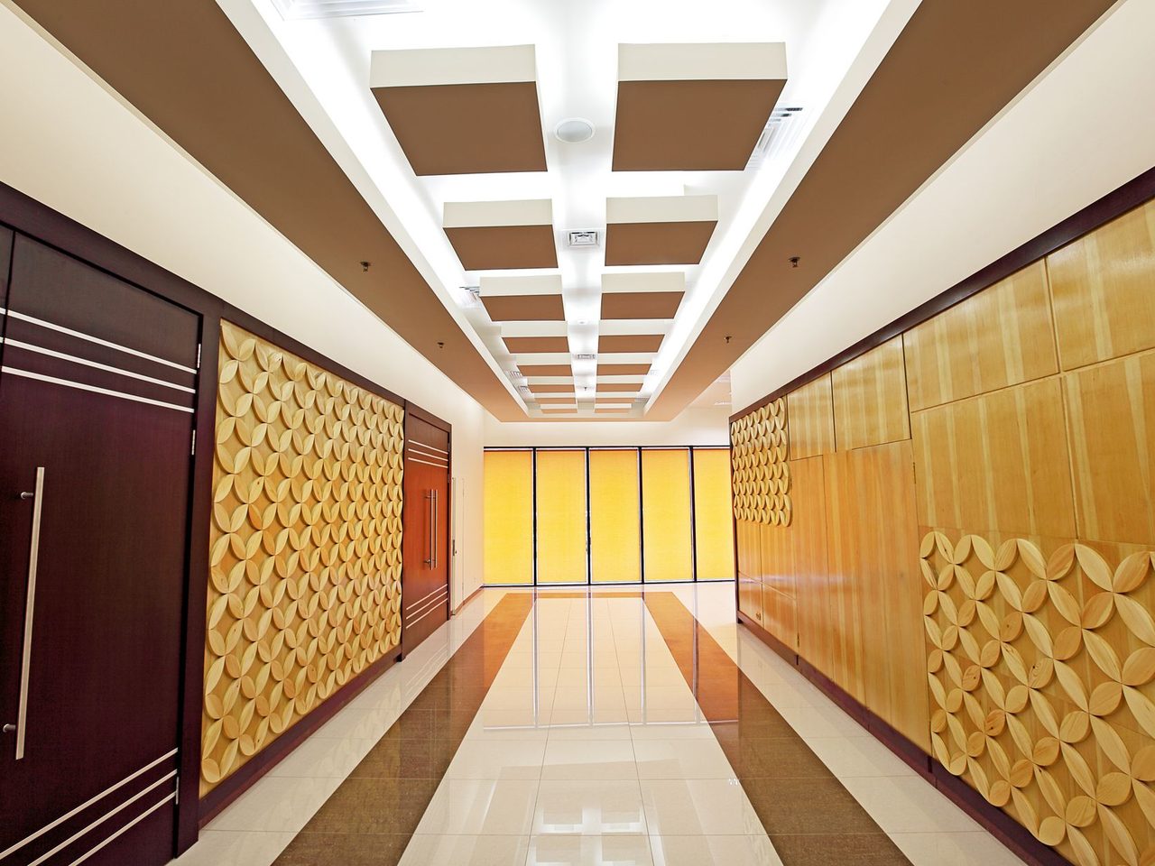 Hotel corridor with patterned wall panels and a glossy floor