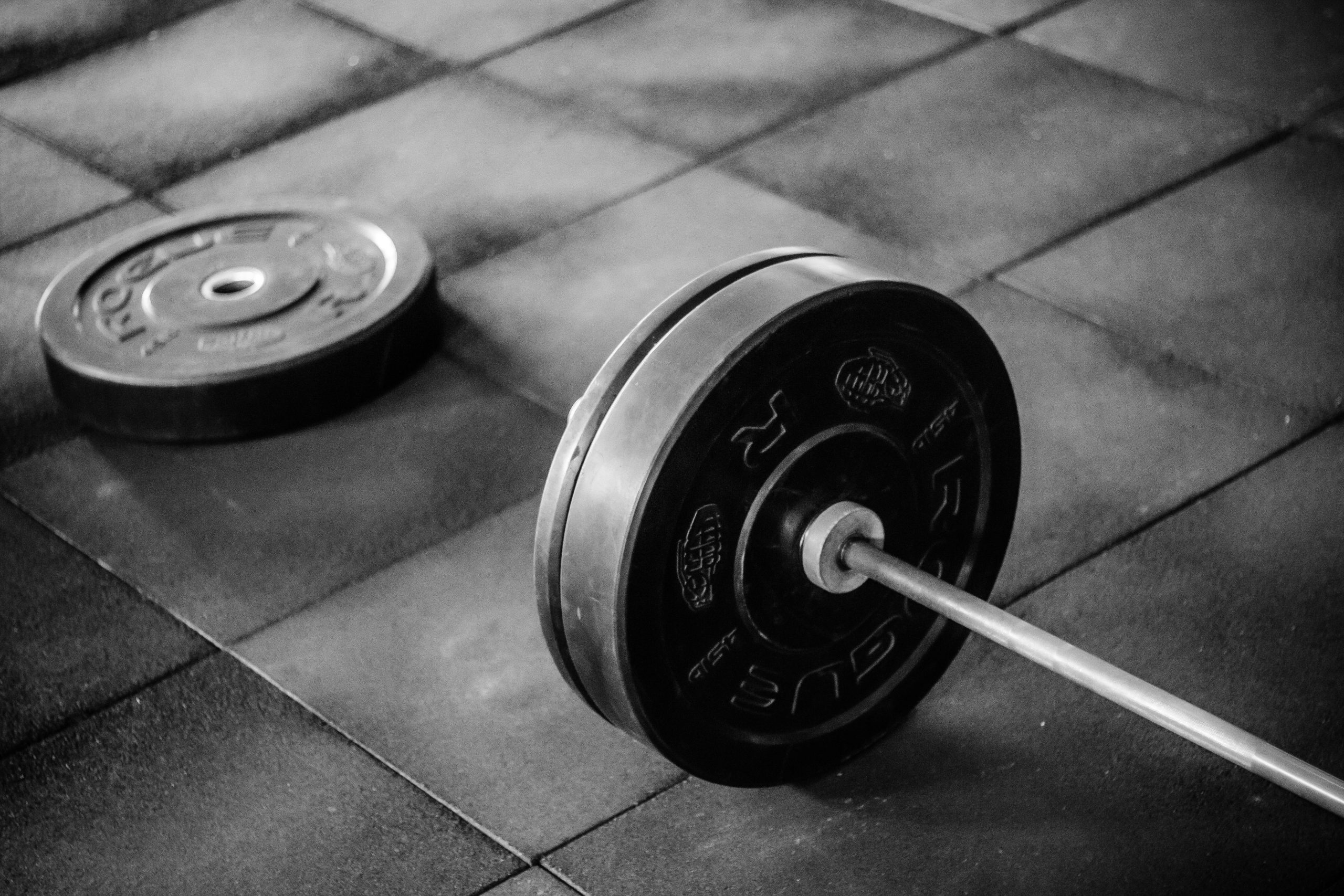 Heavy barbell and weights on rubber mat flooring