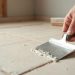 Applying adhesive for luxury vinyl tile installation over a radiant-heated floor system