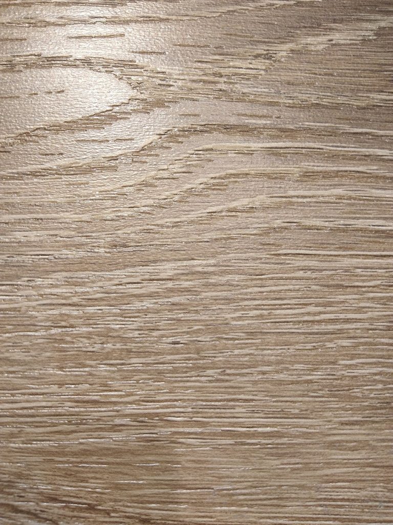 Close-up of an embossed oak-grain surface on a laminate panel