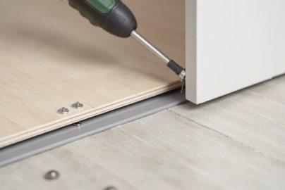 LVP transition strip installation showing proper gap sizing for a floating floor